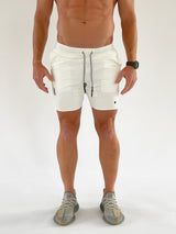 These shorts feature a utility loop for a shirt or towel, multiple pockets including a hidden zipper pocket for secure storage, and laser-cut diamond cutout vents for ventilation.